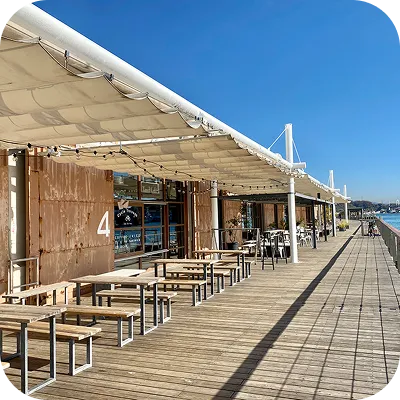 写真:海沿いのテラス席にテーブルがたくさん並んでいます