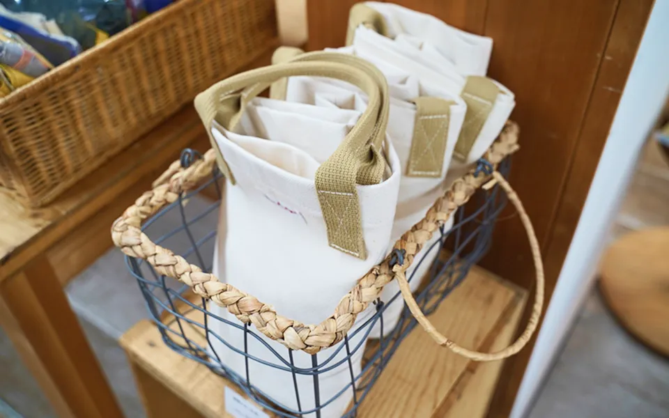 かごの中に白いトートバッグが3つはいってます