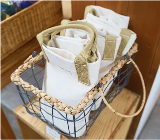 写真:かごの中に白いトートバッグが3つはいって